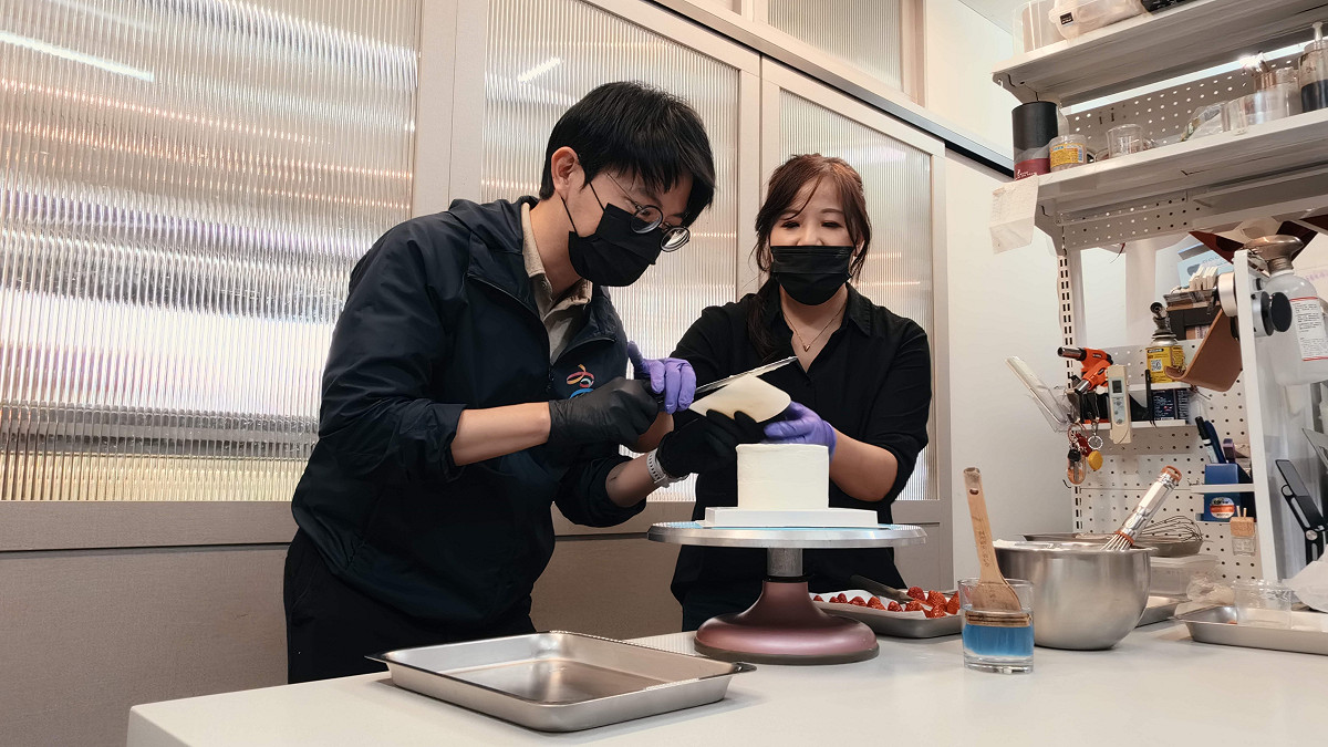 林楷軒(左)在洪薏芬(右)指導下，體驗師承東京和菓子學校的甜點手藝。 圖：高雄市青年局/提供