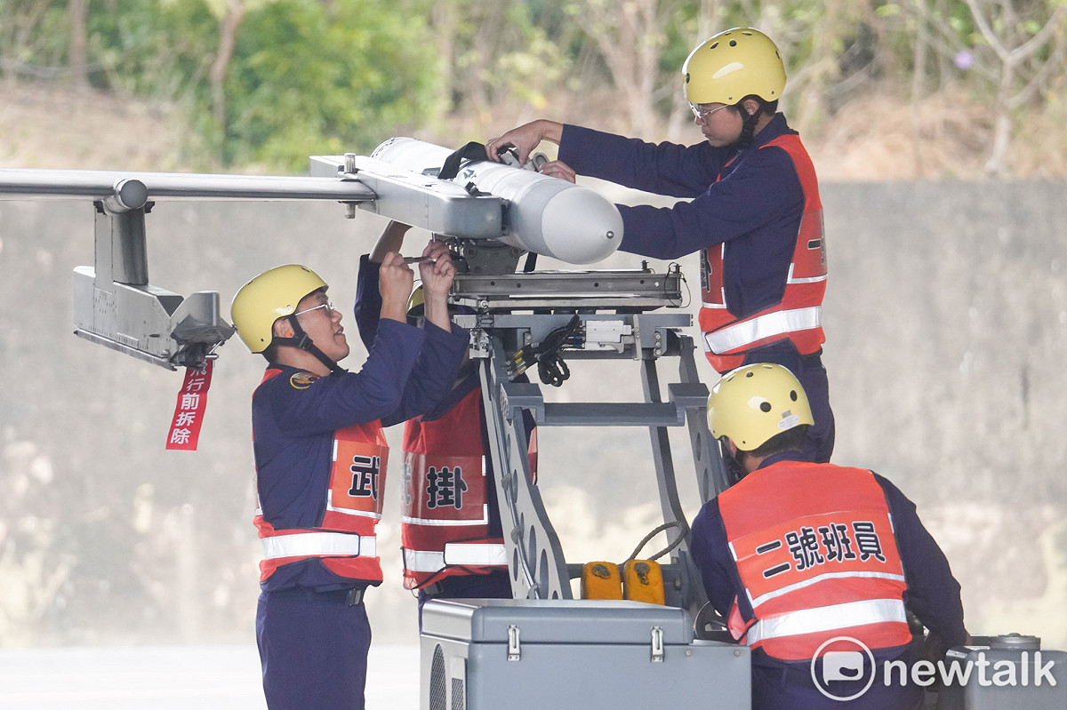 空軍第四戰術戰鬥機聯隊的武掛人員合力將一枚AIM-120飛彈掛載在F-16V戰機上。 圖：張良一/攝