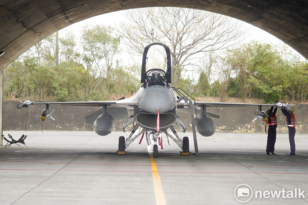 空軍第四戰術戰鬥機聯隊的武掛人員合力將一枚AIM-120、一枚AIM-9M飛彈掛載在F-16V戰機上。 圖：張良一/攝