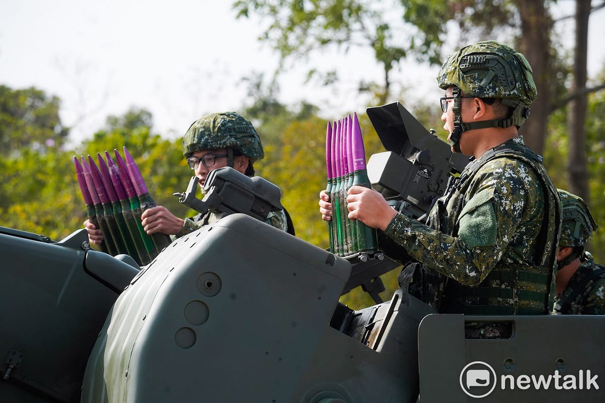 空軍第七九五旅官兵在防空攔截演練時，兩位士兵從後方的彈藥箱內取出彈藥，裝到前方的自動裝彈機內。（紫色彈頭為訓練用的假彈。） 圖：張良一/攝