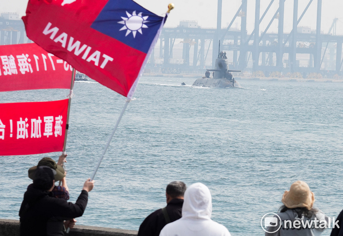 台灣首艘國造潛艦海鯤號今在高雄外海首度進行潛航測試，當海鯤號現身高雄港時，海軍256戰役退役軍官和大批在港邊見證歷史性的一刻，並揮舞著書寫台灣的國旗和加油布條。 圖：張良一/攝