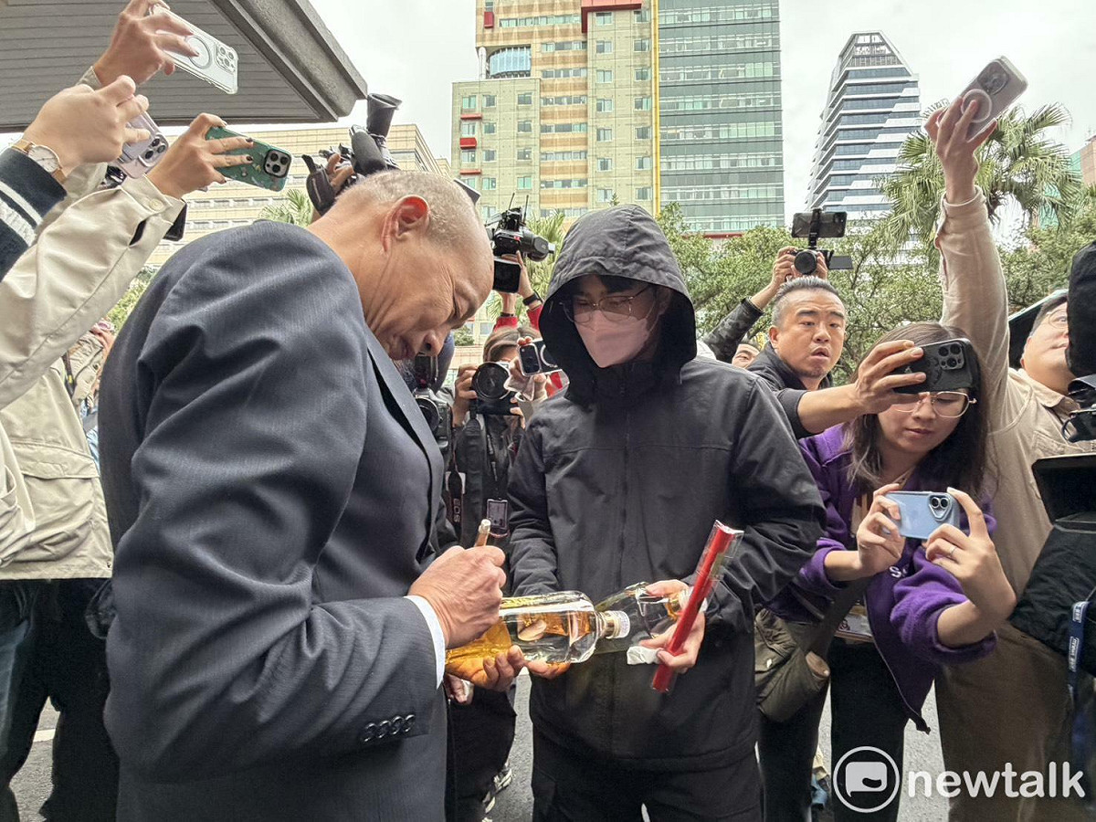 韓國瑜幫一對母子在立法院紀念酒上簽名。 圖：高逸帆／攝