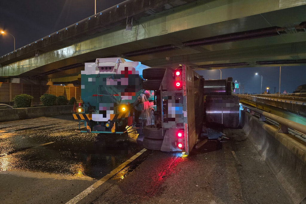 國道1號南向台南市仁德區路段2日傍晚發生全聯結車與槽罐車事故，造成槽罐車載運的汽油洩漏，全聯結車載運鋼捲翻落、後板架側翻。（警方提供）中央社記者楊思瑞台南傳真　115年2月2日