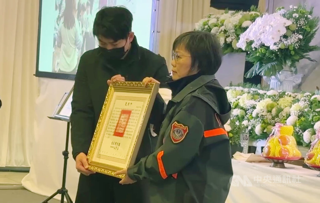 基隆市消防局仁愛消防分隊小隊長詹能傑在火場捨身救人殉職，家屬3日舉行公祭，內政部長劉世芳（右）到場追思並頒發褒揚令，由詹能傑胞弟詹庭豪（左）代表接受。中央社記者王朝鈺攝　115年2月3日