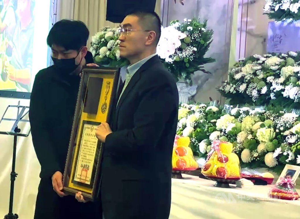 基隆市消防局仁愛消防分隊小隊長詹能傑在火場捨身救人殉職，家屬3日舉行公祭，基隆市長謝國樑（右）頒發追晉分隊長令及獎章，由弟弟詹庭豪（左）代表接受。中央社記者王朝鈺攝　115年2月3日