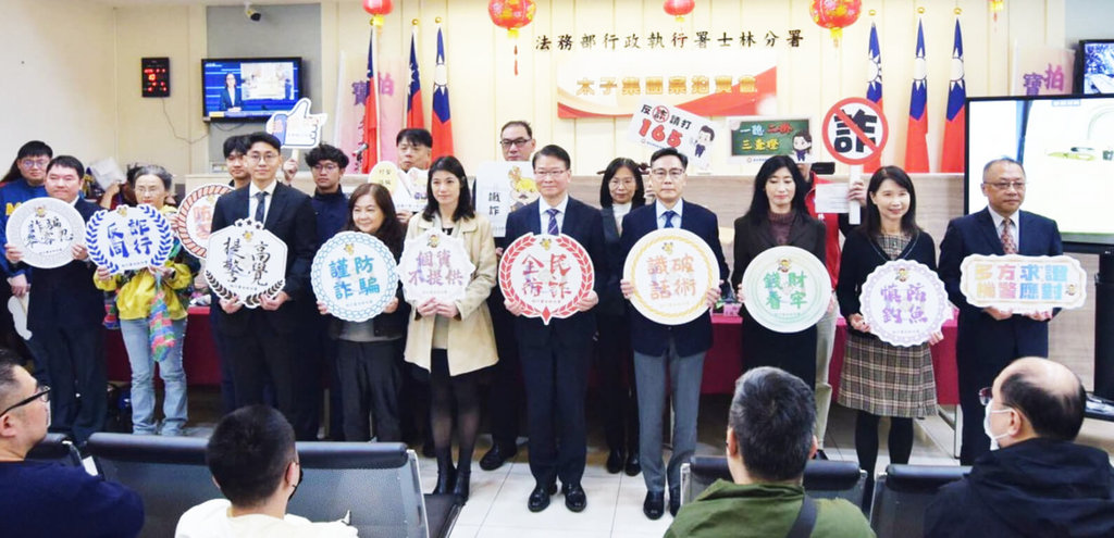 法務部行政執行署士林分署3日舉辦跨國犯罪組織「太子集團」首場犯罪所得拍賣會，行政執行署長繆卓然（前排右4）、台北地檢署檢察長王俊力（前排右5）等人共同高舉標語，宣示聯合打詐決心。（士林分署提供）中央社記者謝君臨傳真　115年2月3日