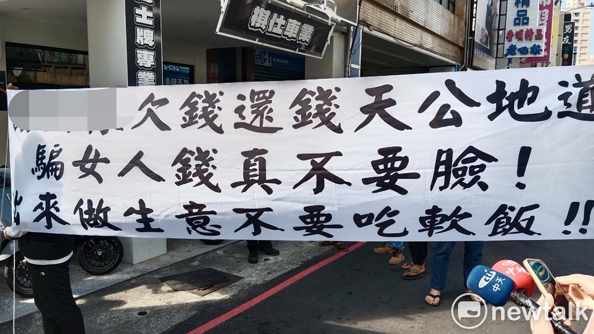 葉女在友人陪同下，到謝姓前男友位於八德二路的車業公司前，拉布條抗議渣男「吃軟飯、不要臉」。 圖：孫家銘攝