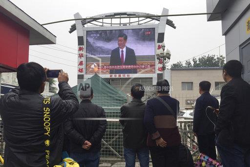 中共19屆新領導班子今天上午選出，北京車站聚集了民眾，正在收看總書記習近平介紹政治局新任七常委。 圖：達志影像/路透社