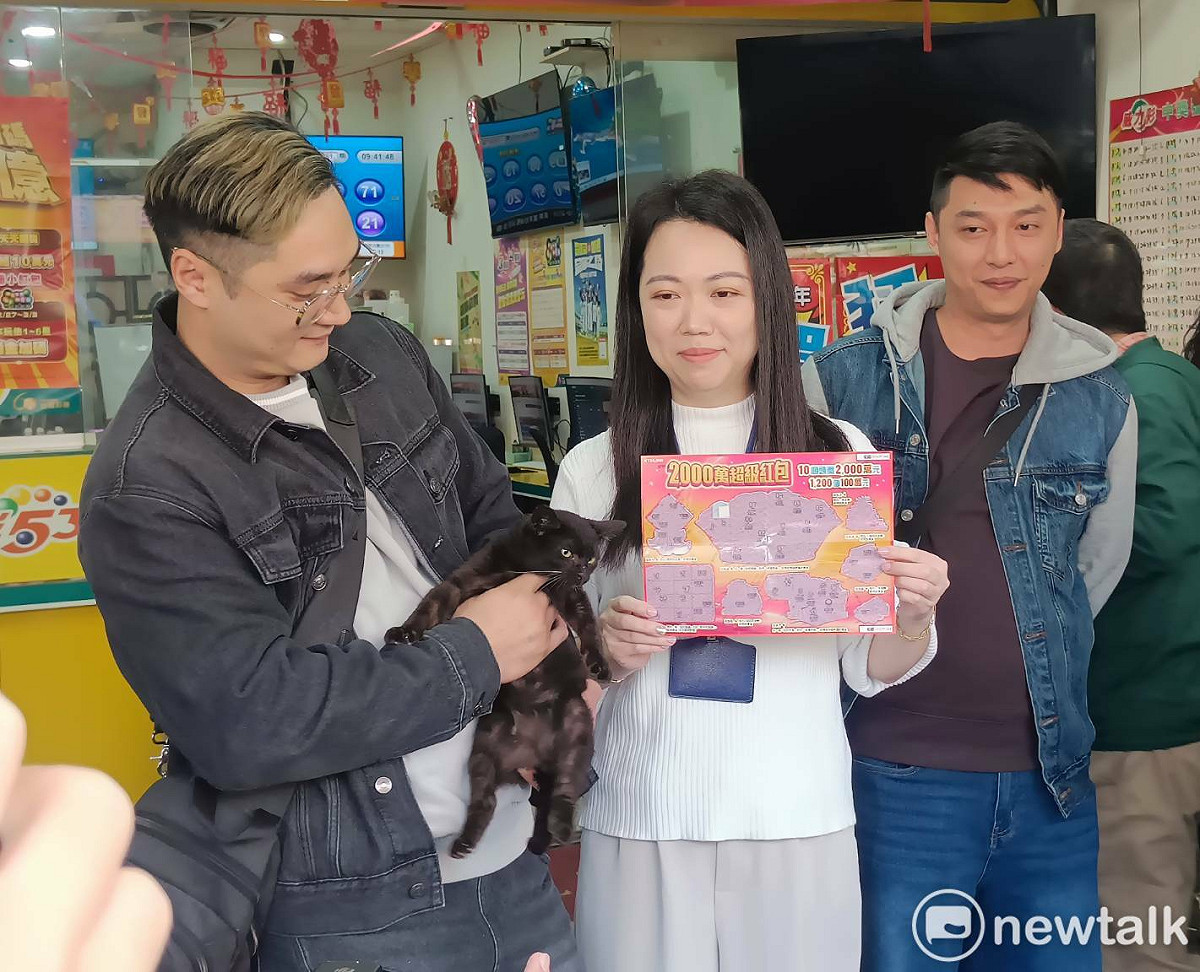 陳先生（左）現身彩券行受訪，說出救貓及中百萬獎的經過。 圖：唐復年/攝