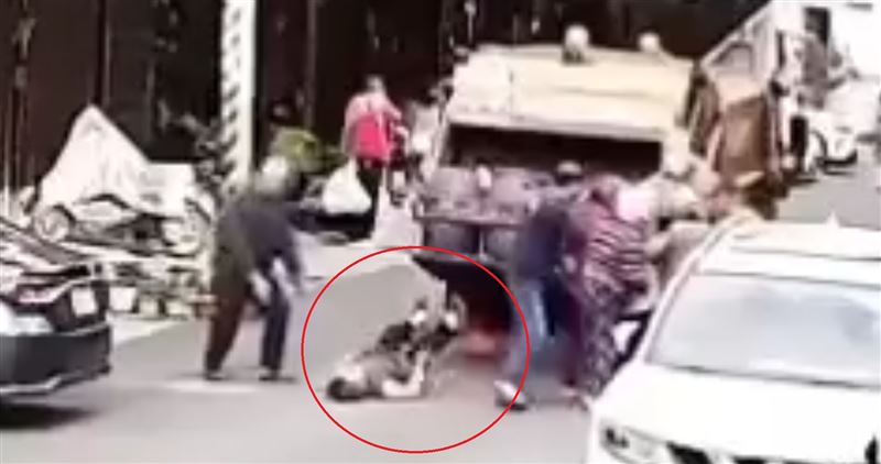 垃圾車疑因壓力過大，造成脫鉤，後尾斗上彈重擊民眾。 圖：翻攝畫面