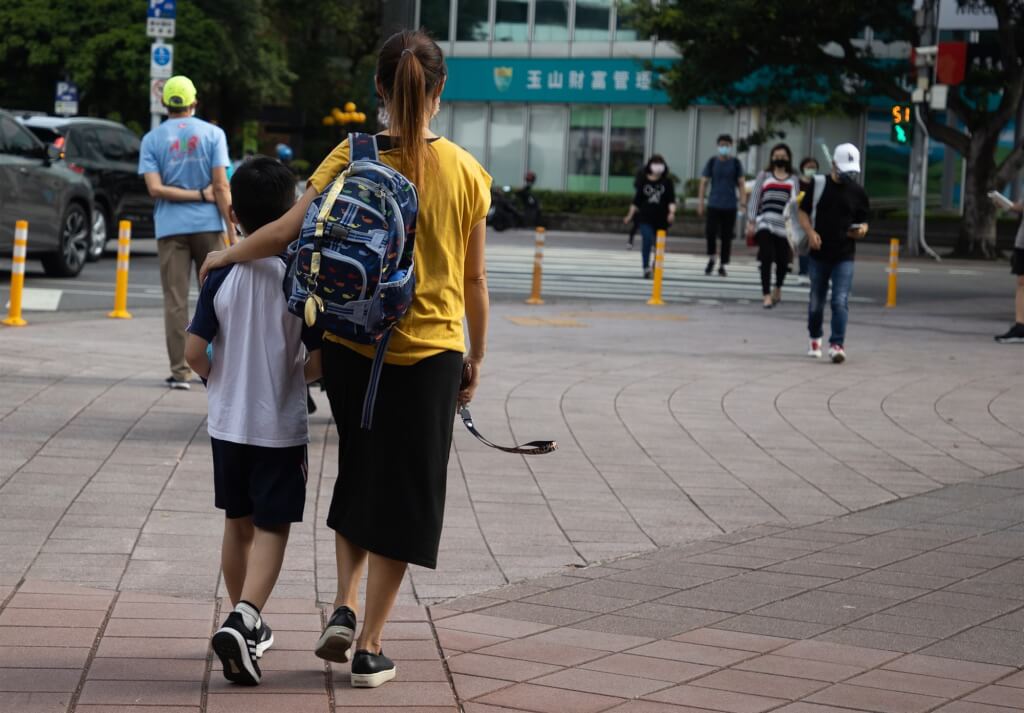 台北市宣布推動「育兒減少工時」試辦計畫，家有12歲以下孩子的家長減少工時1小時。圖為台北市松山區一間國小外家長接送孩子。 圖：（中央社檔案照片）