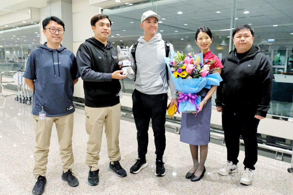 目前效力美國職棒大聯盟克里夫蘭守護者隊的台美混血好手費柴德（Stuart Fairchild）（中）26日晚間搭機抵台，將投入經典賽台灣隊，中職也派員赴機場迎接。  圖/中央社