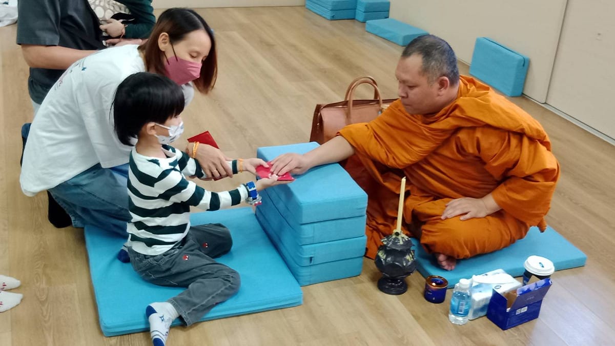 來自泰國的上座部僧侶隆興師父，送給小朋友開運紅包。 圖：孫家銘攝