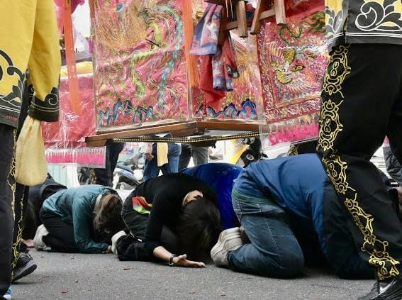 邱議瑩(左二)跟著信眾一起「鑽轎底」祈求國泰民安。 圖：邱議瑩辦公室/提供