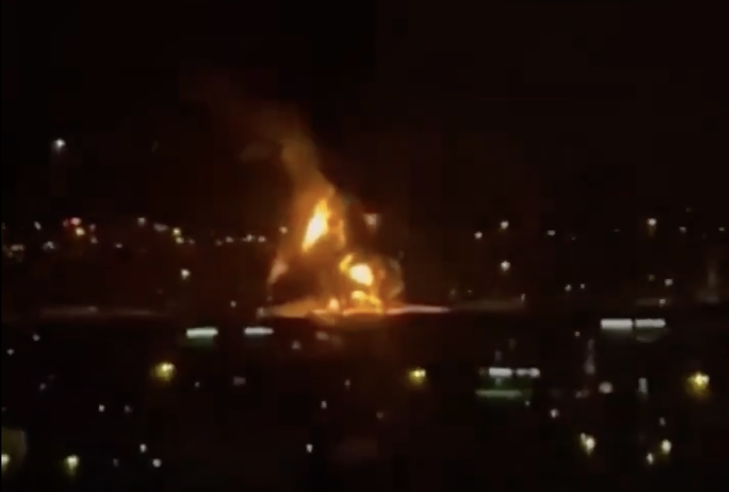 杜拜國際機場附近一座油槽16日凌晨遭無人機擊中起火，夜空可見巨大火焰與濃煙竄升。 圖：截取自 X @theglobal4u 影片