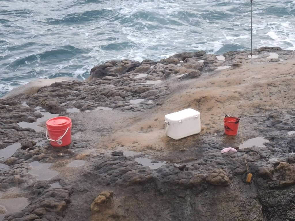 新北市瑞芳區台2線海岸傳出釣客落海失蹤，警方發現疑似70歲陳男遺留的紅色水桶及白色冰箱，16日上午動員陸海空擴大搜索。（讀者提供）中央社記者王朝鈺傳真　115年3月16日