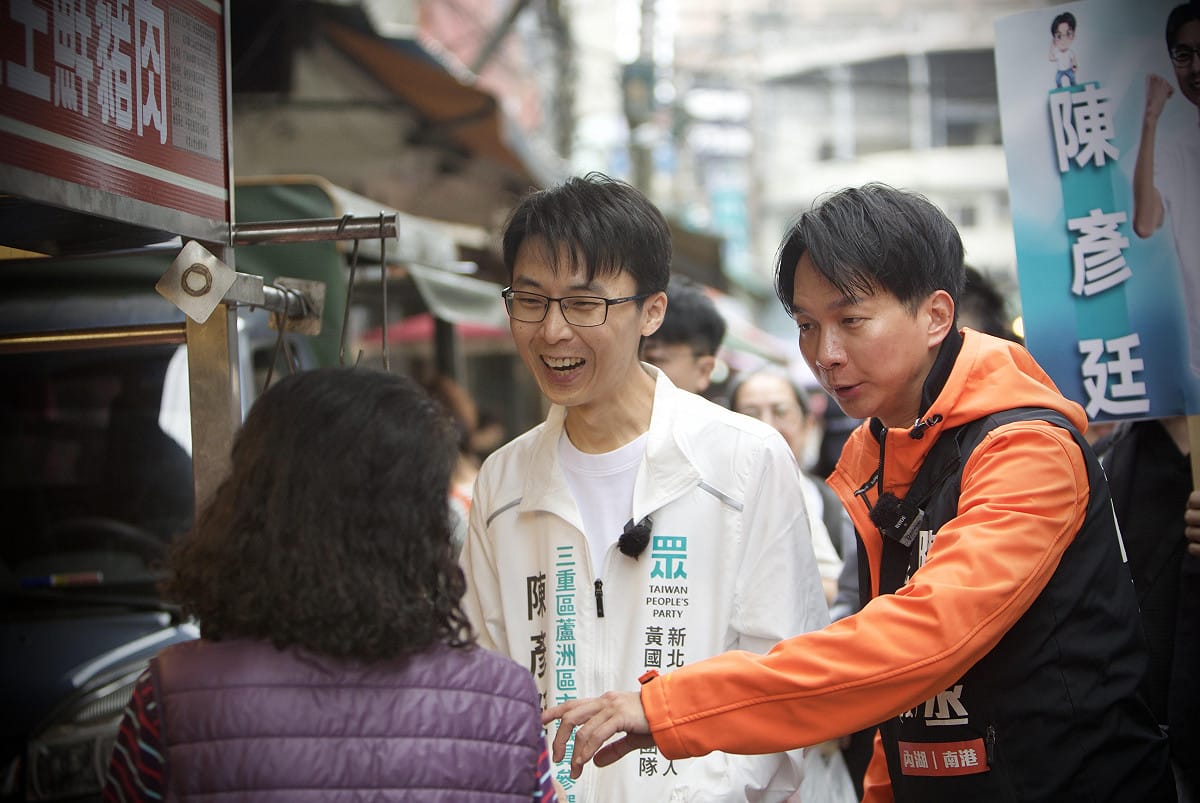 民眾黨新北市議員參選人陳彥廷今首次進行市場掃街，民眾黨台北市議員陳宥丞親自傳承與民眾互動的技巧。 圖：陳彥廷競選團隊 / 提供