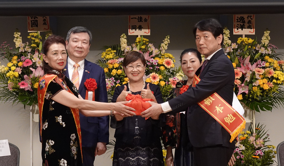 駐日代表李逸洋（後左1）與僑委會委員長徐佳青（中）22日出席日本臺灣商會聯合總會總會長交接典禮及晚會。第13屆總會長洪益芬（左1）將印信交給第14屆總會長賴本勉（右1）。 圖：取自李逸洋臉書