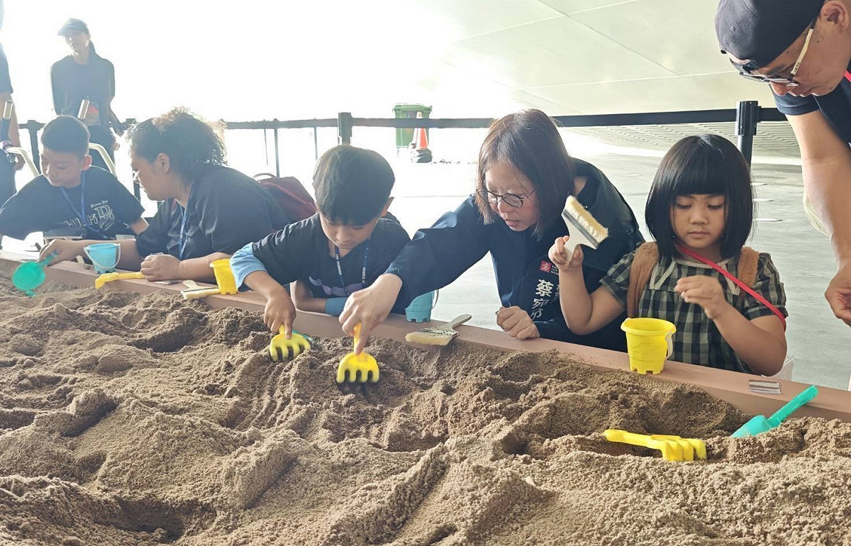 蔡宛芬(右二)與社區兒少一起參與2026恐龍酷樂園化石挖掘活動。 圖：高雄市社會局/提供