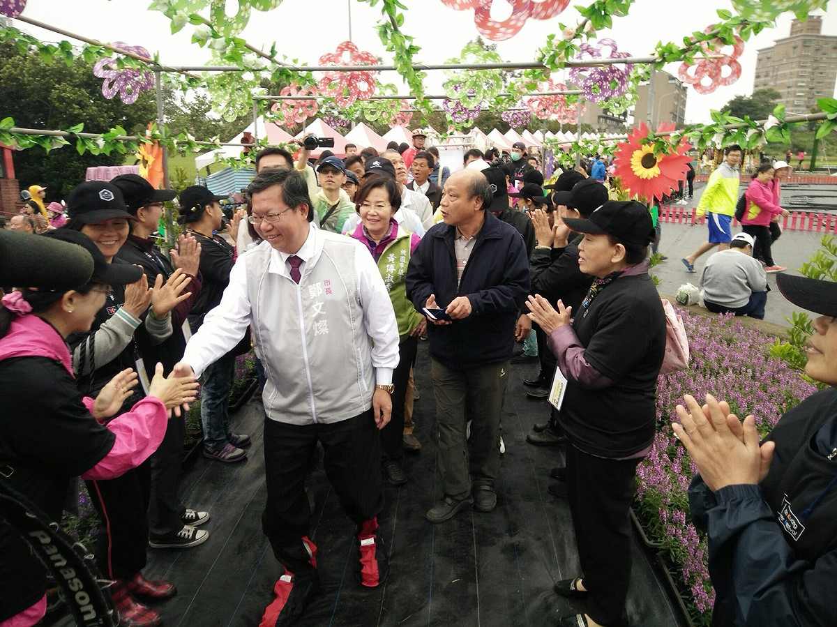 今(4)天是桃園花彩節中壢花區的開展日，許多人慕名前來賞花拍照，桃園市長鄭文燦也現身「桃園市第三屆花彩節－中壢場暨鮮旅騎緣賞花趣活動」活動現場，與來到花區賞花的遊客熱情互動。 圖：桃園市農業局提供