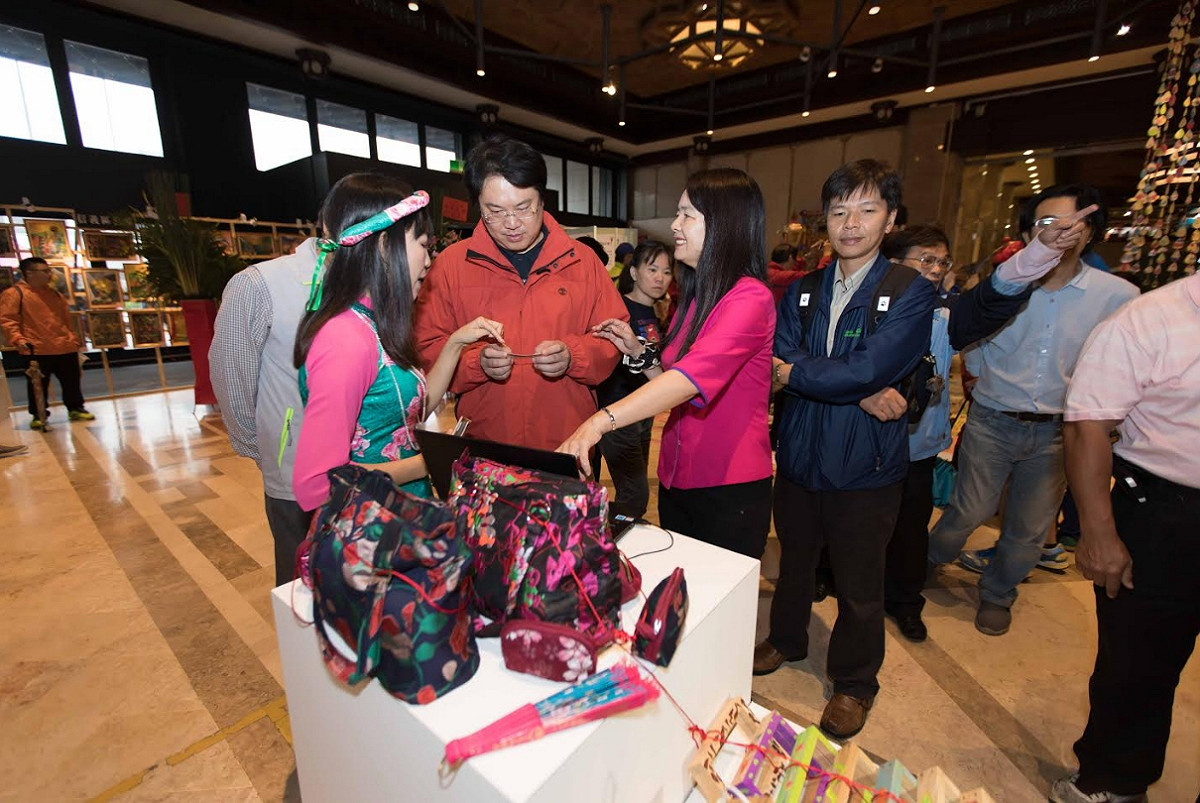 基隆市社區營造聯合成果展在基隆文化中心大廳登場，林右昌仔細端詳展出品。 圖：基隆市政府/提供