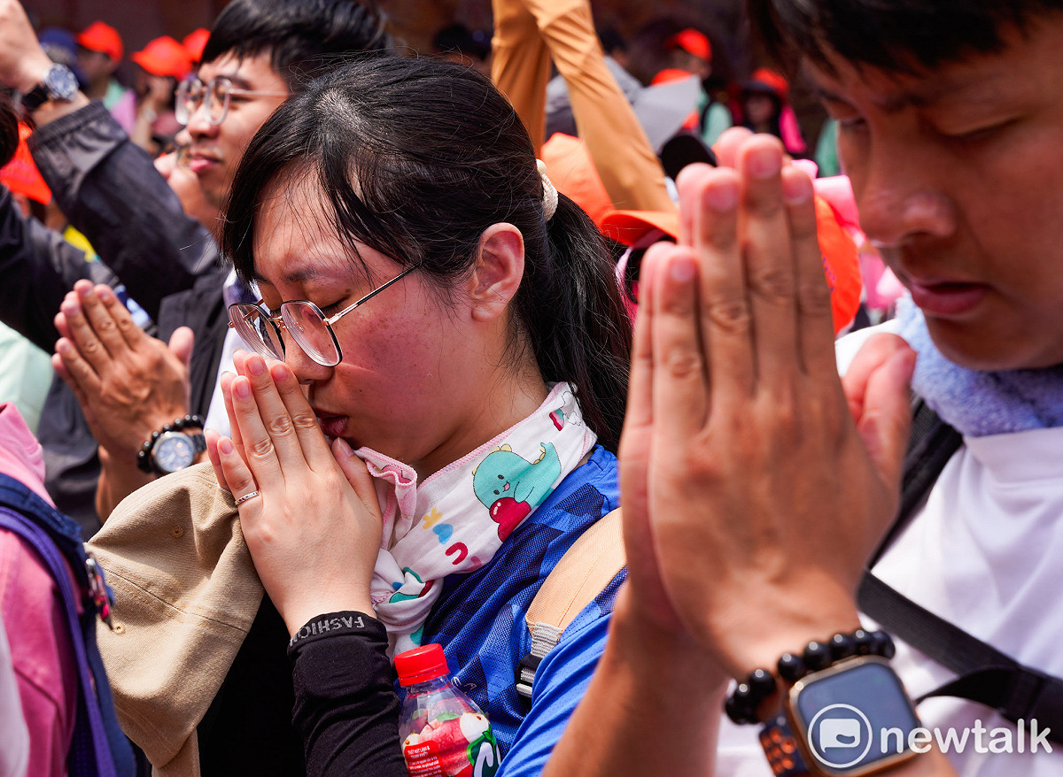 白沙屯媽祖中午在大甲鎮瀾宮駐駕，香燈腳在鎮瀾宮前雙手合十向媽祖祈福。 圖：張良一/攝
