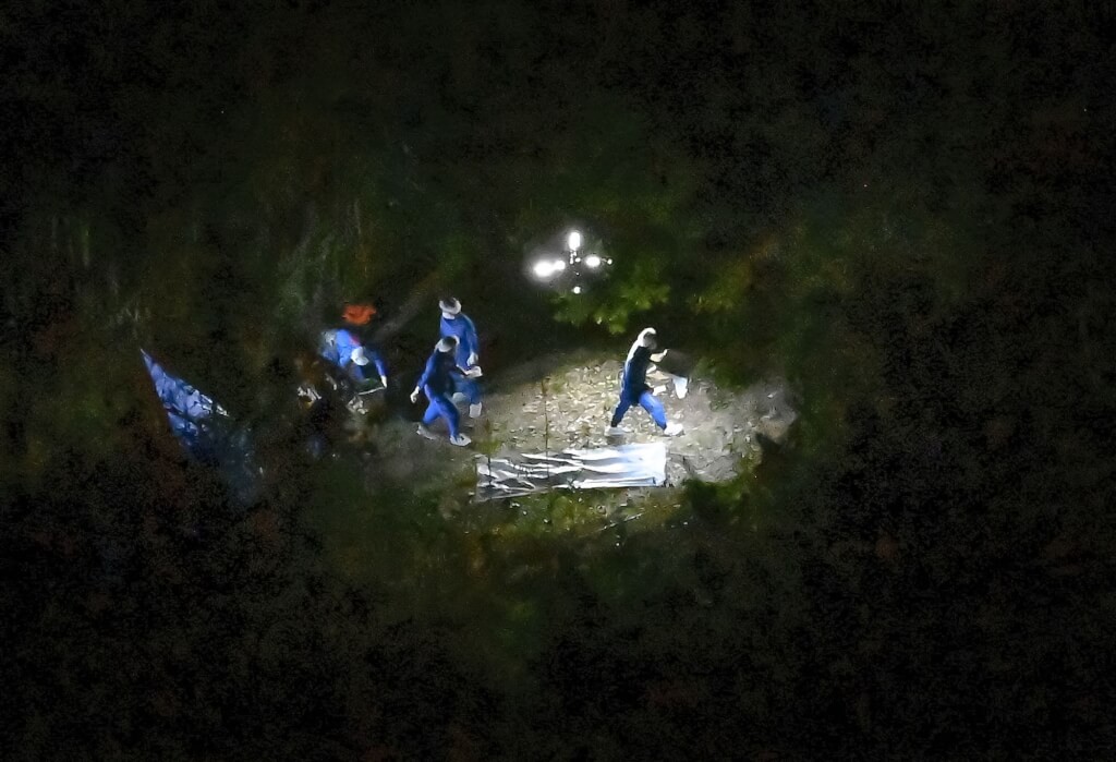 京都府警方13日晚間在南丹市山區發現一具身分不明的遺體，調查人員進行勘查。（共同社） 圖：中央社提供