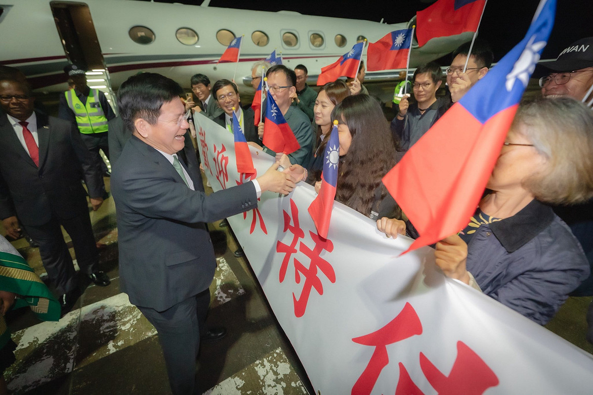 外交部長林佳龍以總統特使身分抵達史瓦帝尼，當地大使館同仁、技術團與僑胞深夜冒雨接機，熱情揮舞國旗歡迎訪團。 圖：翻攝林佳龍臉書