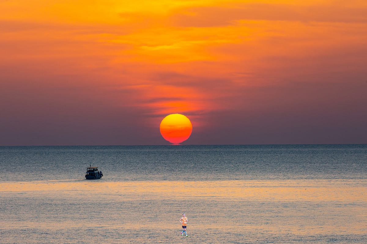 夕陽落入水平面時，呈現酒杯形狀，鄭明典解釋成因，「夕陽底下有『海市蜃樓』現象」，因此成酒杯形狀，也稱作稱OMEGA太陽。 圖：取自鄭明典臉書