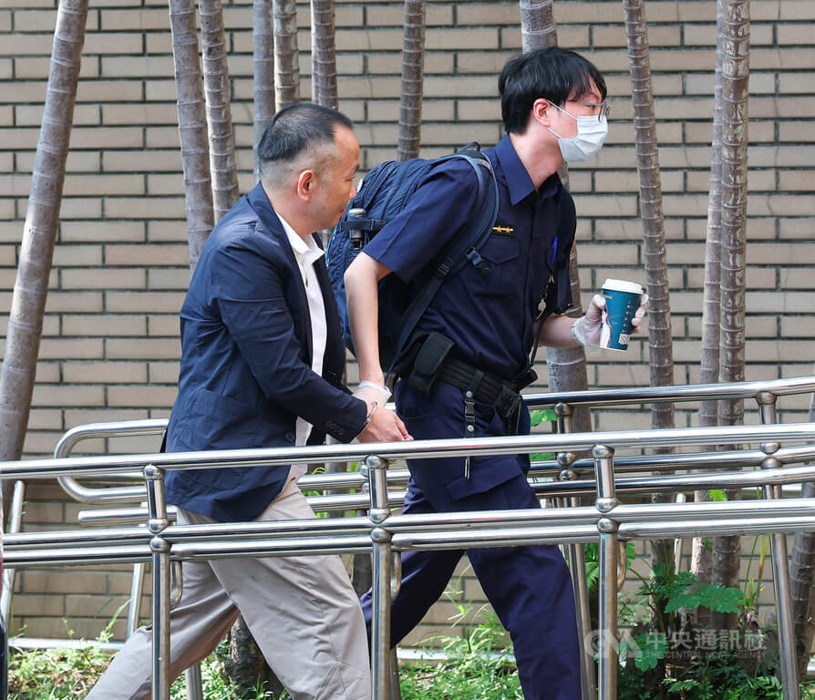 雲云科技負責人曾志新涉殺害梁姓技術長案，台北地方法院國民法官法庭22日開庭審理。曾志新（左）在法警戒護下，準備出庭。（中央社檔案照片）