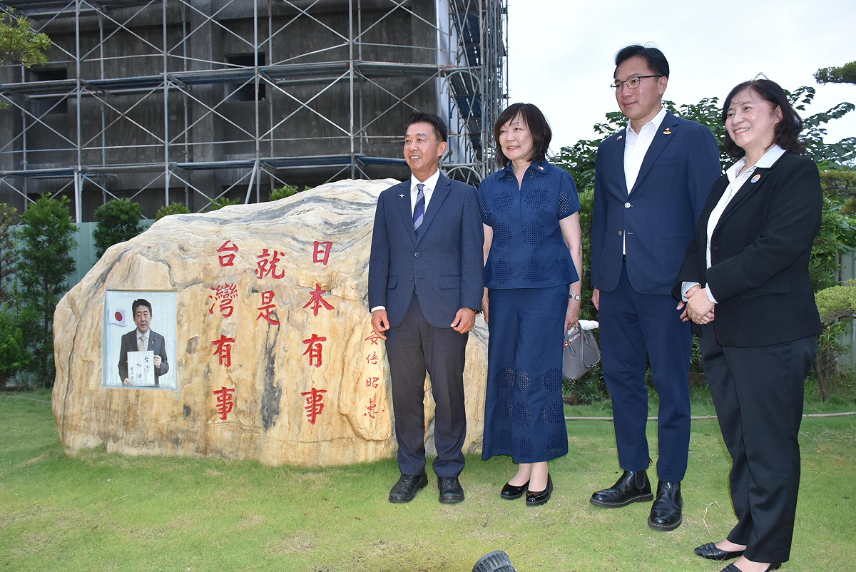 安倍昭惠(左二)、許智傑(左一)、林智鴻(右二)在「台灣有事就是日本有事」字樣的大石旁合影。 圖：孫家銘/攝