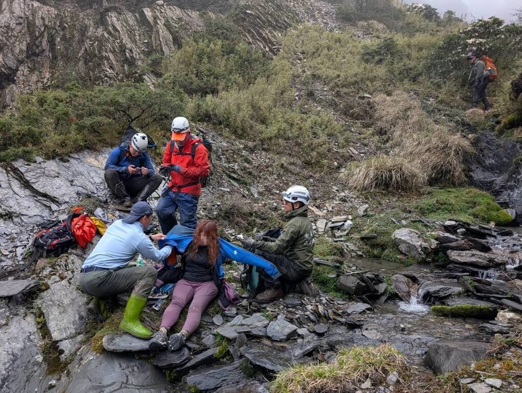 一支登山團體攀登南投合歡山東峰，10日傍晚集合時，發現一名女團員未報到，查詢確認手機定位後通報消防局，搜救隊員11日在溪谷附近尋獲，女子意識清楚，給予食物及衣物保暖後，送回安全處。（南投縣消防局提供）中央社記者吳哲豪傳真　115年5月11日