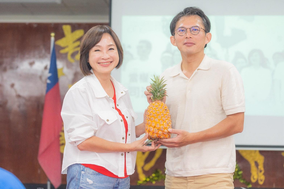 民眾黨在高雄深藍指標選區「果貿社區」舉辦論壇，柯志恩(左)大方到場送鳳梨給黃國昌(右)。 圖：柯志恩服務處/提供