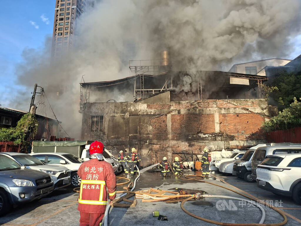 新北市三重區泉州街一處頂樓鐵皮加蓋建築28日清晨起火竄出濃煙，消防人員獲報到場馳援。（翻攝照片）中央社記者曹亞沿傳真　115年5月28日