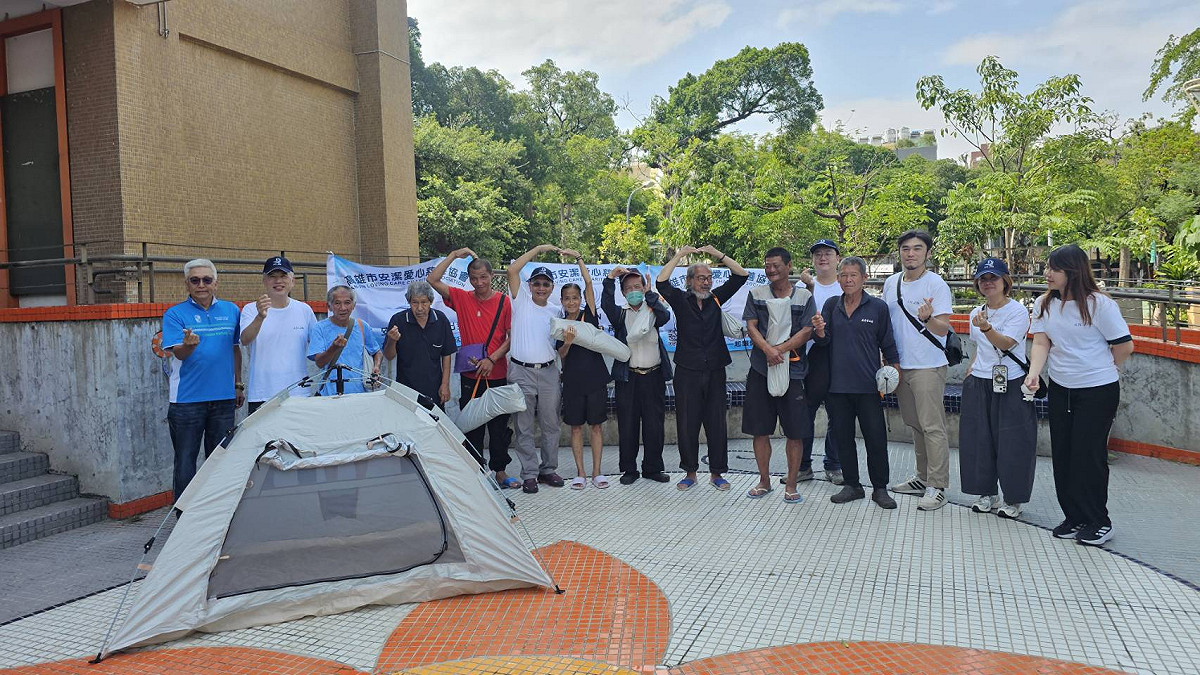 高市三民公園的無家者接過實用帳篷後，比大愛心感謝高雄市安潔愛心慈善協會與捐助者。 圖：孫家銘/攝