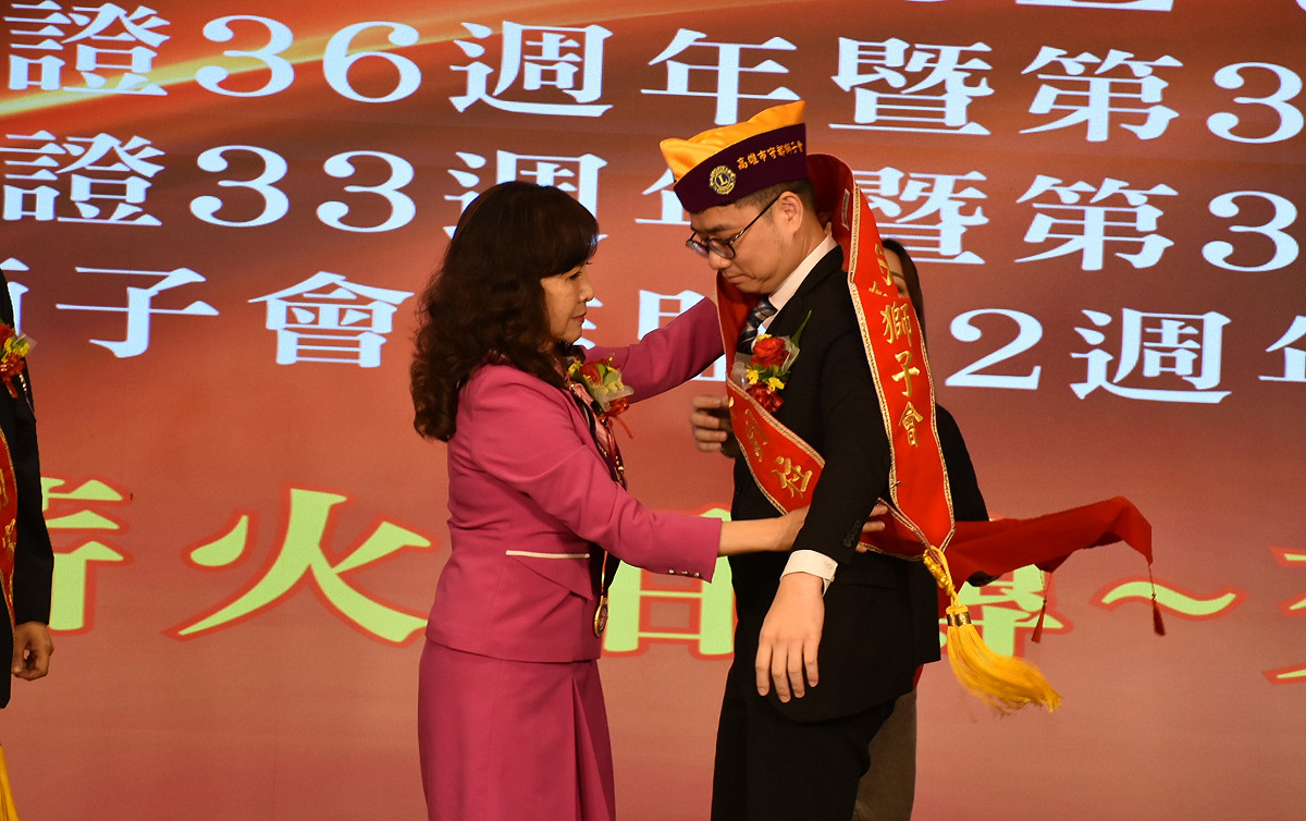 吳佳臻(左)為劉柱均(右)披上高雄市守都獅子會會長紅彩帶。 圖：孫家銘/攝
