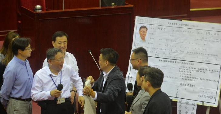 台北市長柯文哲今(10)日在議會總質詢時，民進黨籍議員製作一張大型入黨申請表海報，邀請柯文哲入黨。 圖：中央社
