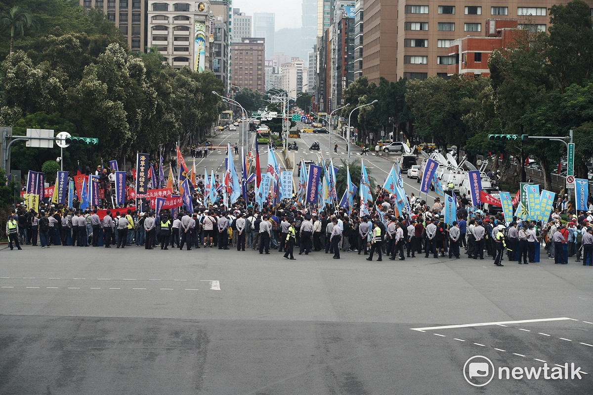 反軍人年改團體佔據行政院前的忠孝西路東西向車道，要求政務委員林萬億出來說清楚，否則不撤離。 圖：張良一/攝