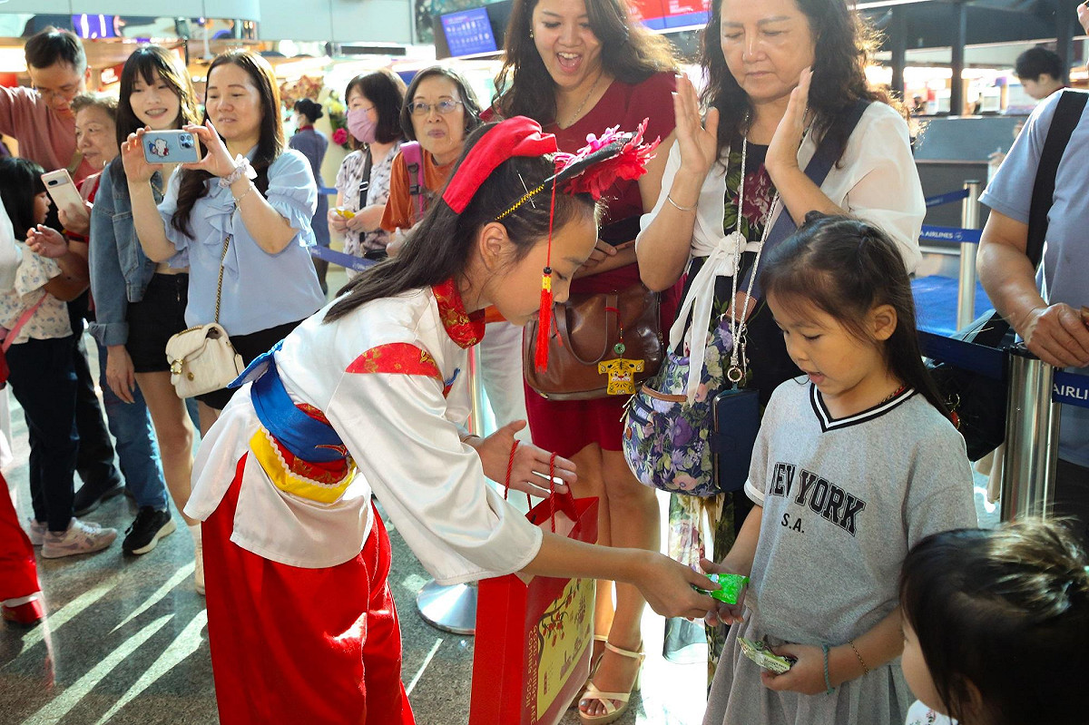 金門中正國小鼓吹隊員與旅客互動，分享來自金門的文化熱情。 圖：財團法人昇恒昌基金會／提供