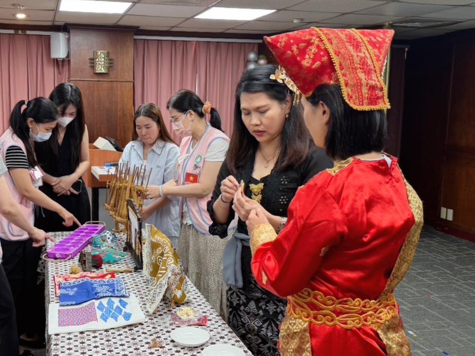 曹寒妮（右二）帶領現場新住民體驗盤子舞舞者的服裝及頭飾。 圖：移民署提供