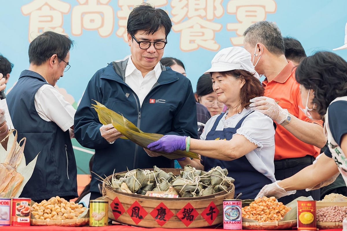 陳其邁(左)由肉粽老店店員指導傳統綁粽手藝。 圖：高雄市政府/提供