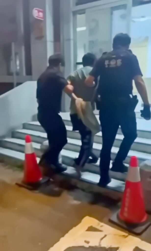 嘉縣警局水上分局6日晚跑入一名男子（圖中）向員警求助，數名民眾也跟著進入分局指該男子擦撞多部車輛逃逸，男子突然情緒失控，員警在其身上發現毒品以現行犯逮捕，並戒護就醫移送法辦。（警方提供）  圖/中央社