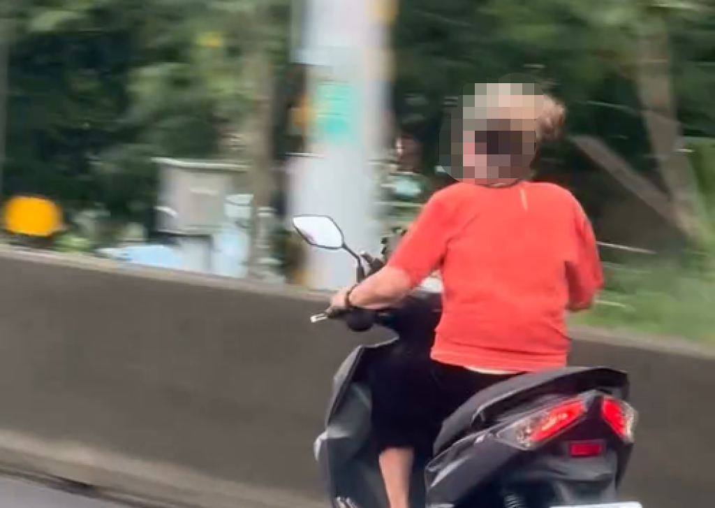 阿嬤騎車狂飆國道路肩，安全帽都噴飛。 圖：翻攝自Threads