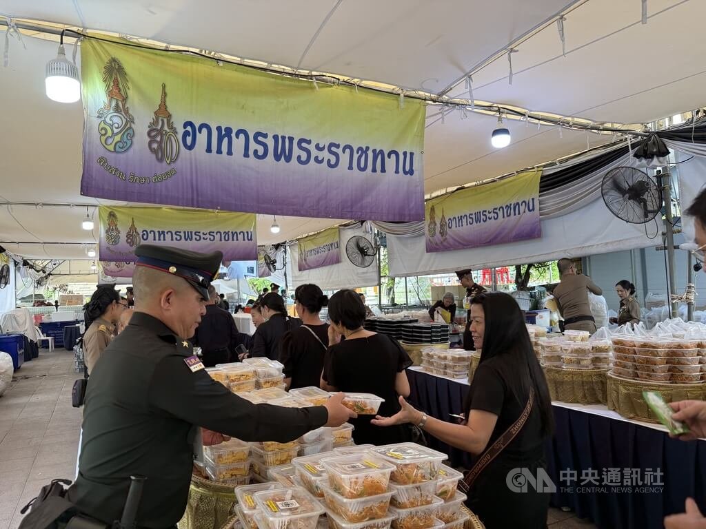 泰國大皇宮外設置御賜餐食發放區，提供免費食物與飲水供民眾取用。 圖：中央社提供