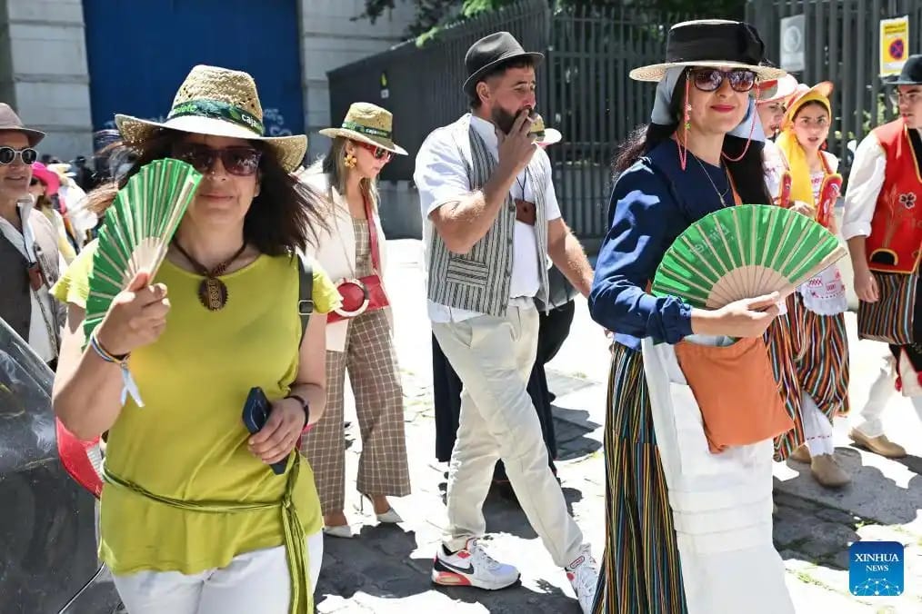 西班牙部分地區氣溫飆破 44°C，馬德里街頭民眾紛紛拿出扇子搧風降溫。 圖：翻攝自百度