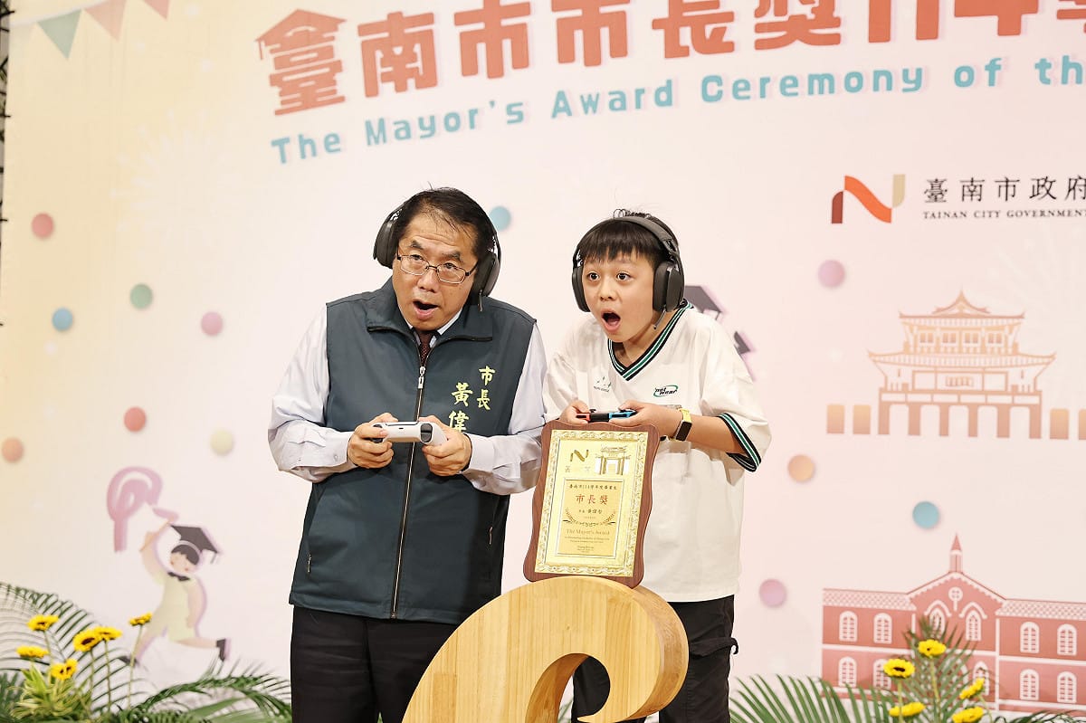 台南市政府今日舉辦市長獎頒獎典禮，由於黃偉哲任期也將在年底屆滿，今年典禮以「市長畢業趴」為主題，現場設置拍照背板及驚喜紀念禮物，也有不少學生帶來親手製作要送市長的畢業禮物，包括寫有「偉哲市長畢業快樂」的小布條以及書法作品等，讓黃偉哲相當感動。 圖：台南市政府提供