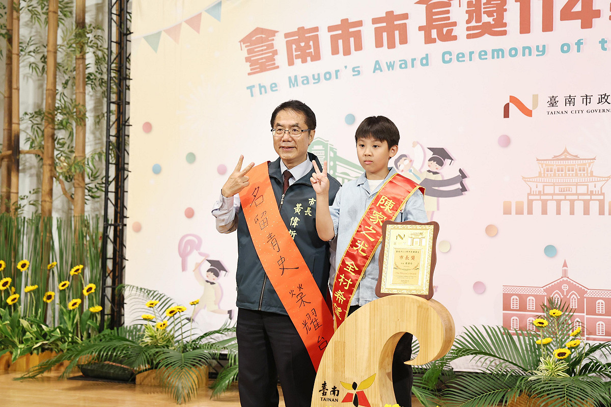 台南市政府今日舉辦市長獎頒獎典禮，由於黃偉哲任期也將在年底屆滿，今年典禮以「市長畢業趴」為主題，現場設置拍照背板及驚喜紀念禮物，也有不少學生帶來親手製作要送市長的畢業禮物，包括寫有「偉哲市長畢業快樂」的小布條以及書法作品等，讓黃偉哲相當感動。 圖：台南市政府提供