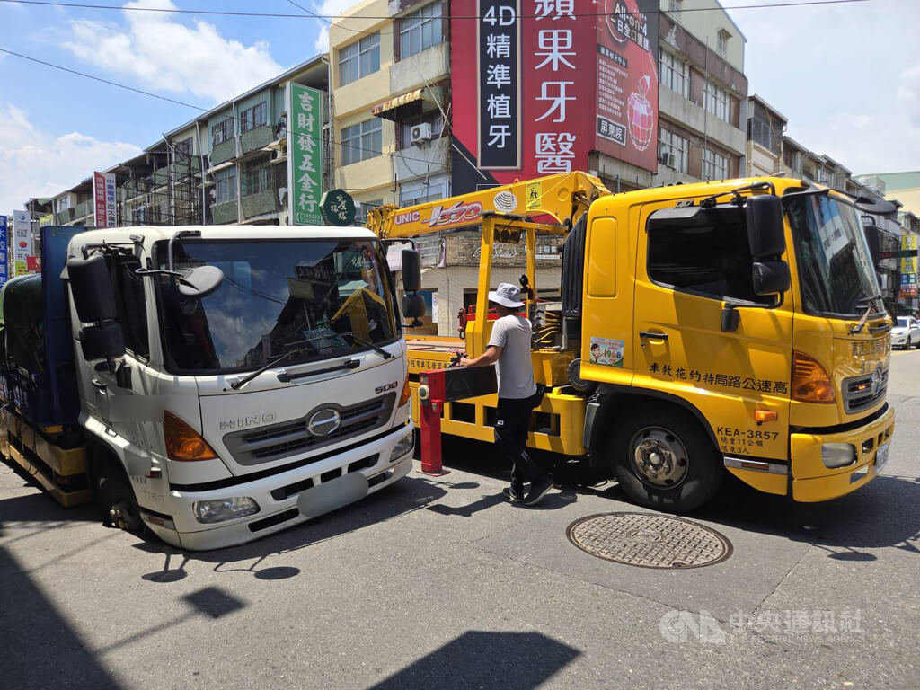 一輛大貨車2日上午於屏東市廣東路前陷天坑，屏東市公所獲報緊急請拖吊車將貨車吊出來。中央社記者黃郁菁攝　115年7月2日