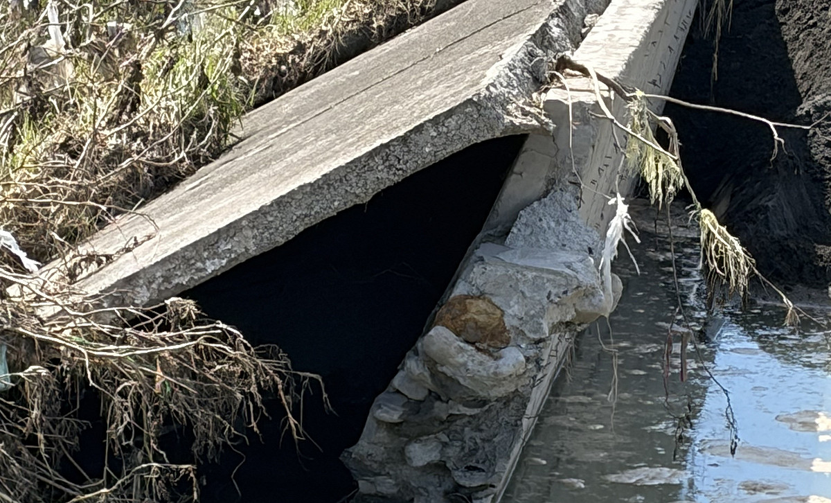 蘇清泉指出潰堤處下方並無基座，僅有河沙堆積，破損的大段堤防中竟看不到一支鋼筋。 圖：蘇清泉服務處/提供