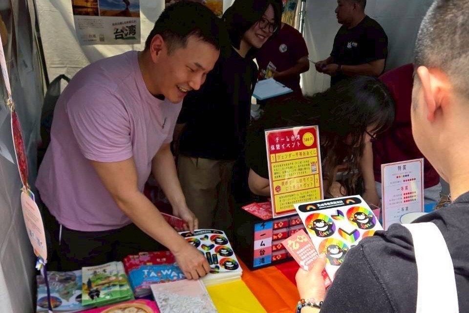 高市觀光局攜手台北駐日代表處設攤推廣高雄觀光，發送日語版「高雄性別友善旅宿摺頁」、高雄熊彩虹貼紙與彩虹小物。 圖：高雄市觀光局/提供